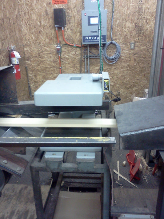 Omega in-line moisture measurement system installed above a board conveyor